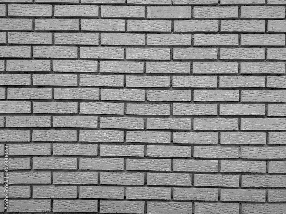 Modern rock stone wall background made of bricks on a wall of the building with rough texture and interesting antique retro natural pattern in black and white