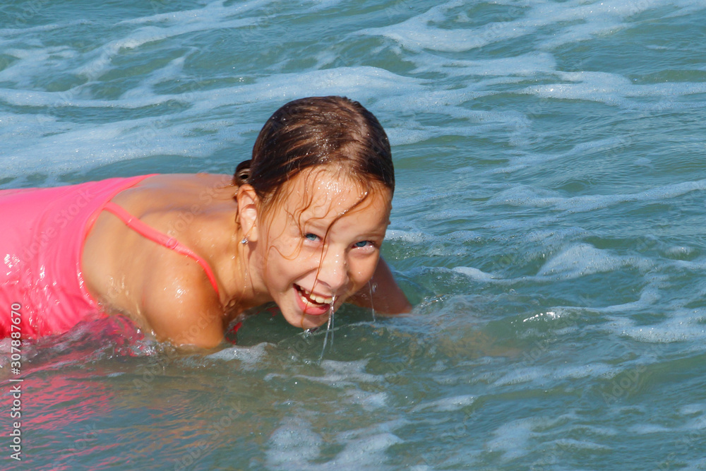 girl swimming in the sea and laughing