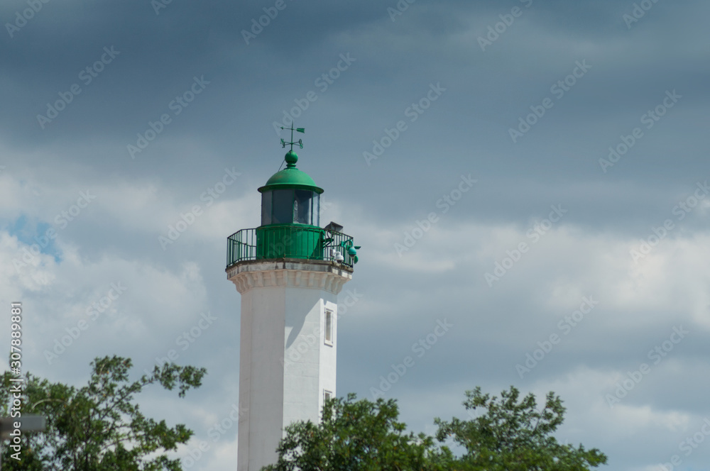 view of green lighthouse in La Rochelle Harbor in France