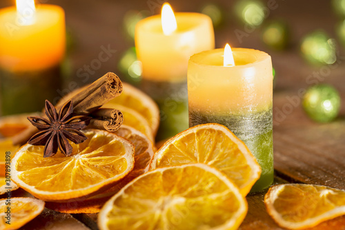 Fototapeta Naklejka Na Ścianę i Meble -  Christmas decoration - candles, spices and orange slices on wood