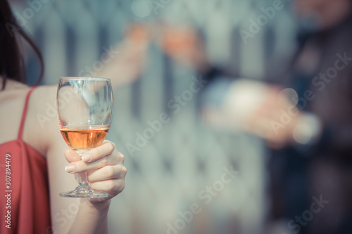 Woman hand holding glasses of whisky in night club.