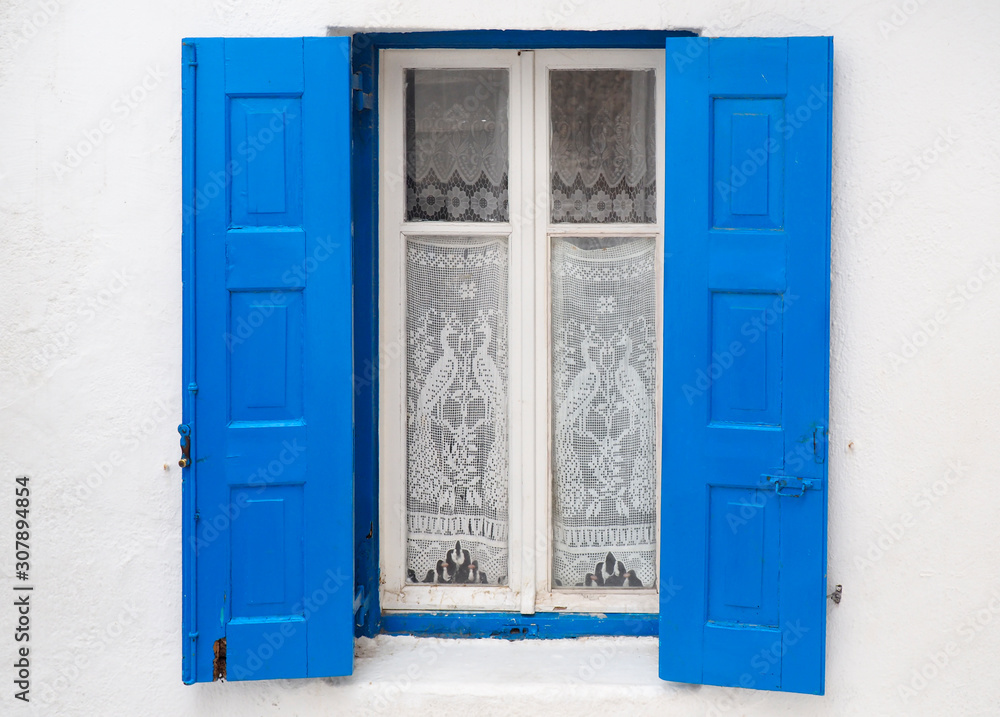 one of the charms of Mykonos, Greek Cycladic island in the heart of the Aegean Sea, are the beautiful colored doors and windows of the houses in the narrow streets of the ancient city