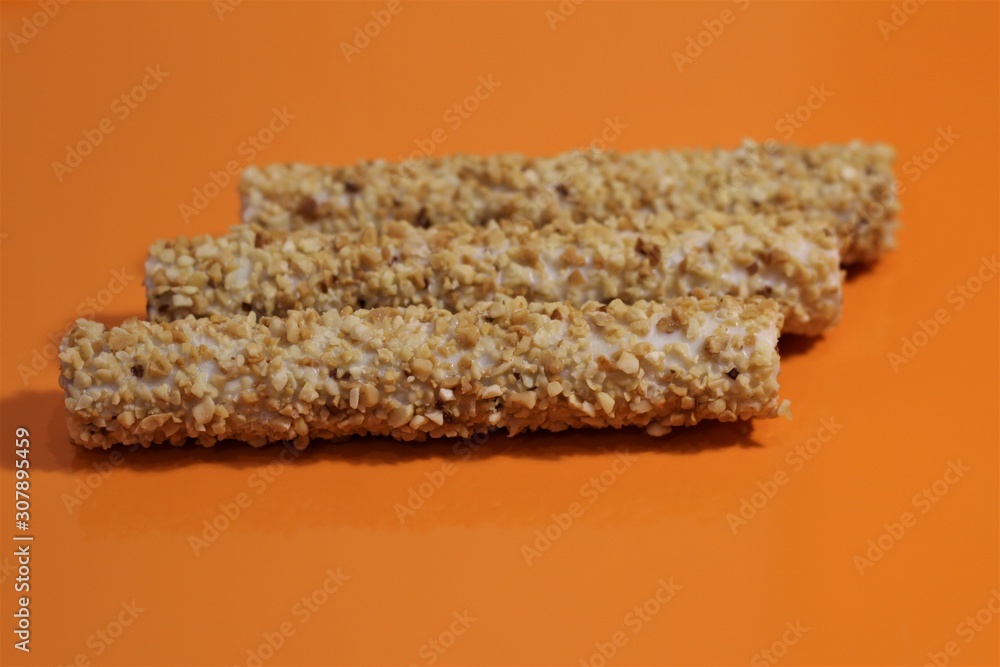 Fototapeta premium sweet rolls in the nuts on an orange table