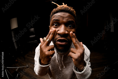 Afro american guy pointing wih his fingers to eyes