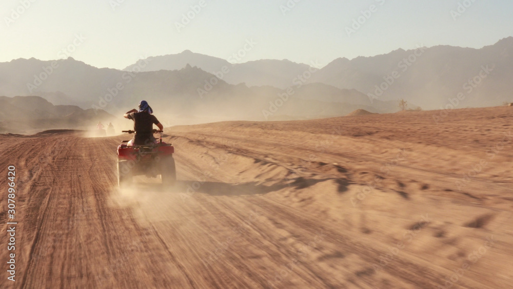Quad bike ride through the desert near Sharm el Sheikh, Egypt.Adventures of desert off-road on ATV.Sand and Sand Borkhan. Rock and sunset. Quad Cycle Travel. Excursion with people. Quad bike ride through the desert near Sharm el Sheikh, Egypt.Adventures of desert off-road on ATV.Sand and Sand Borkhan. Rock and sunset. Quad Cycle Travel. Excursion with people.
