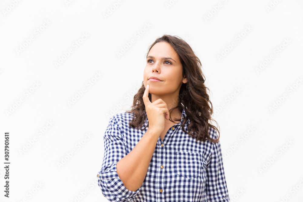 Pensive student girl touching chin and looking away at copy space. Young woman in casual checked shirt standing isolated over white background. Decision making concept Pensive student girl touching chin and looking away at copy space. Young woman in casual checked shirt standing isolated over white background. Decision making concept