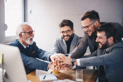 Фототапет A managerial team starting a new project under the wise guidance of a senior executive who inspires teamwork