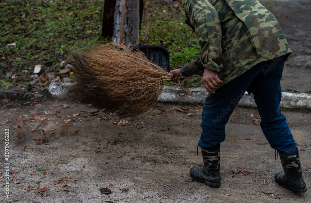 Janitor sweeping a broom yard Janitor sweeping a broom yard