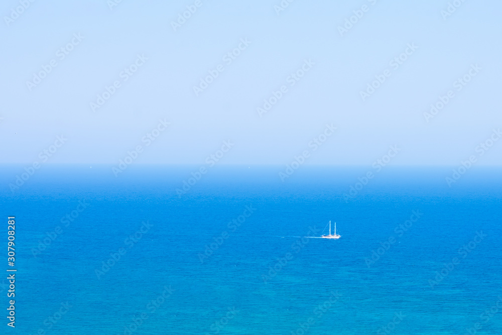Beautiful seascape with calm blue Mediterranian sea, in mist and boat, touristic season, vacation on sunny islands Beautiful seascape with calm blue Mediterranian sea, in mist and boat, touristic season, vacation on sunny islands