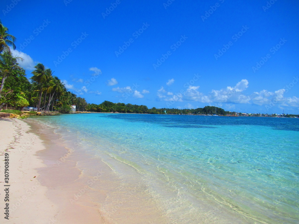 Une plage de sable blanc et la mer turquoise sous un ciel bleu sans nuage Une plage de sable blanc et la mer turquoise sous un ciel bleu sans nuage
