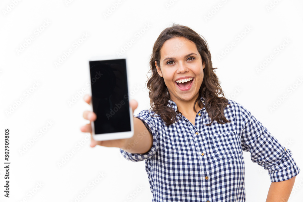 Joyful excited customer showing blank phone screen and shouting for joy. Young woman in casual checked shirt standing isolated over white background. Presentation concept Joyful excited customer showing blank phone screen and shouting for joy. Young woman in casual checked shirt standing isolated over white background. Presentation concept
