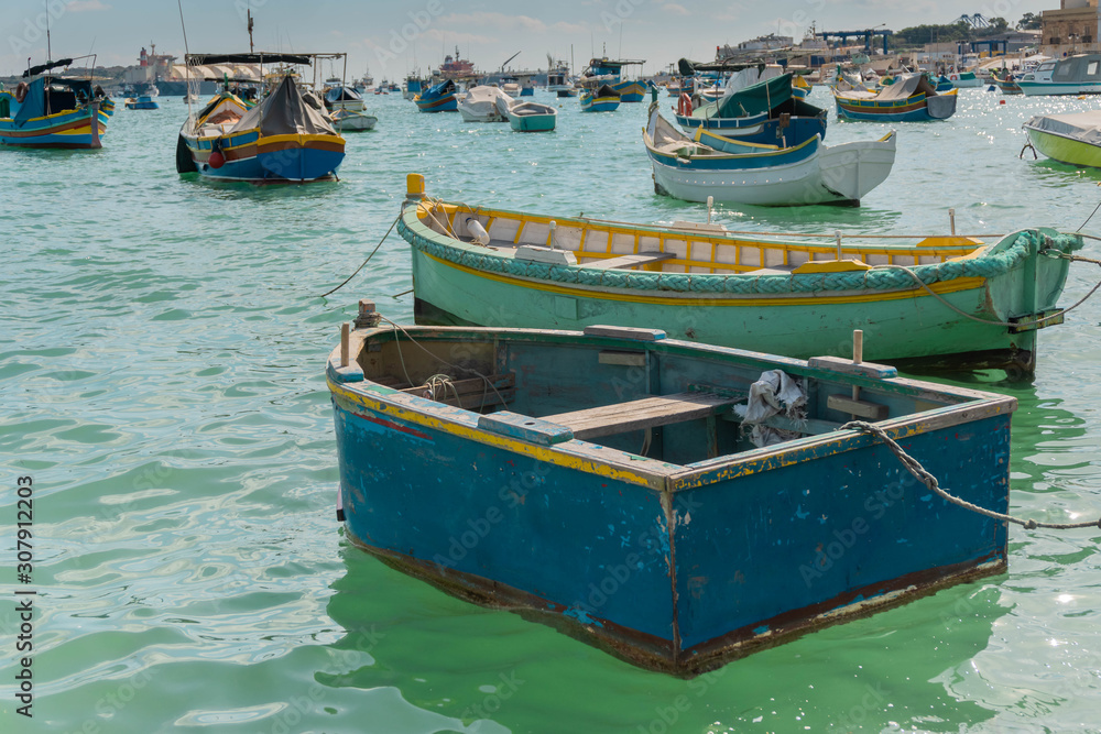 Traditional aged boats in Marsaxlokk village harbor in Malta