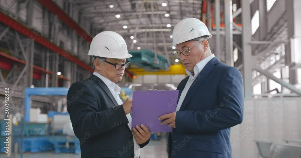 Construction engineers businessmen, teamwork working with tablet. Business team at new factory. Two senior confident business people formal wear discussing deal. investor businessman factory Construction engineers businessmen, teamwork working with tablet. Business team at new factory. Two senior confident business people formal wear discussing deal. investor businessman factory