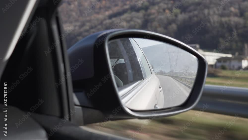 Right rearview mirror of a car closeup while driving Right rearview mirror of a car closeup while driving