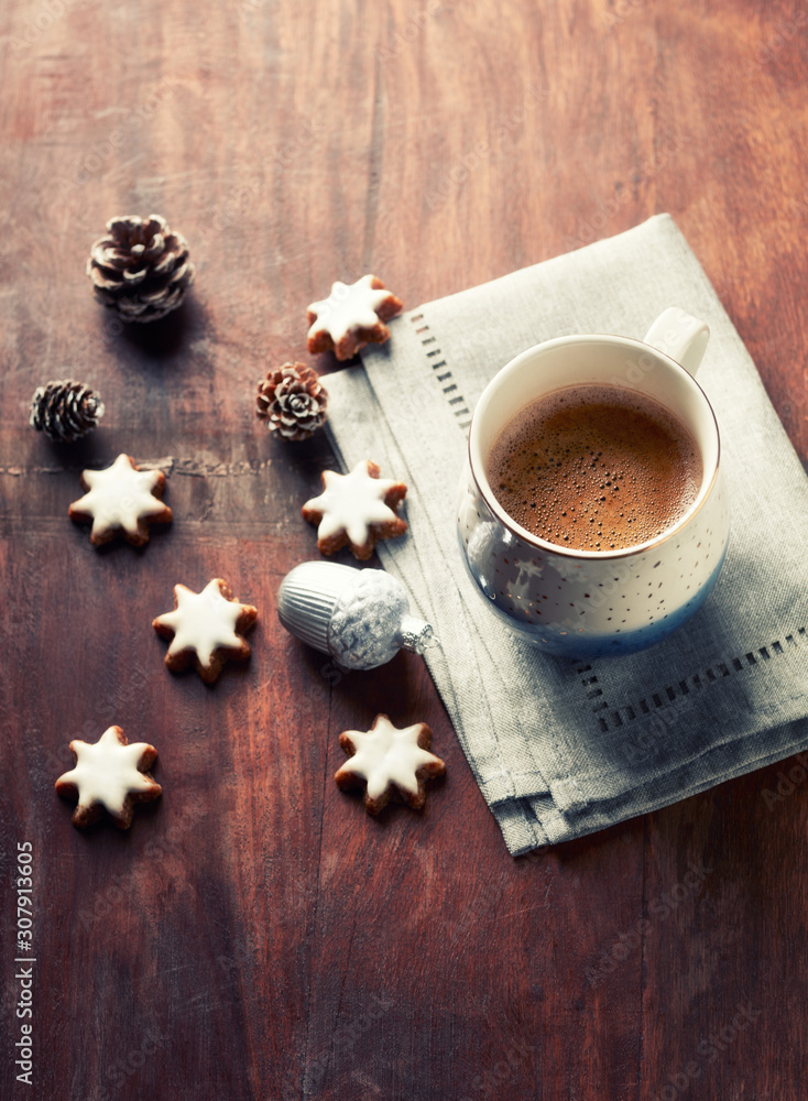 Mug of coffee and Christmas cookies (cinnamon stars) on rustic wooden background. Copy space. Mug of coffee and Christmas cookies (cinnamon stars) on rustic wooden background. Copy space.