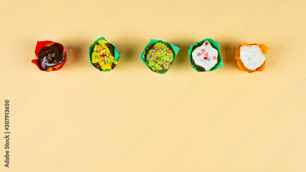 Colorful muffin dancing on yellow background. Concept of bakery products and confectionery.