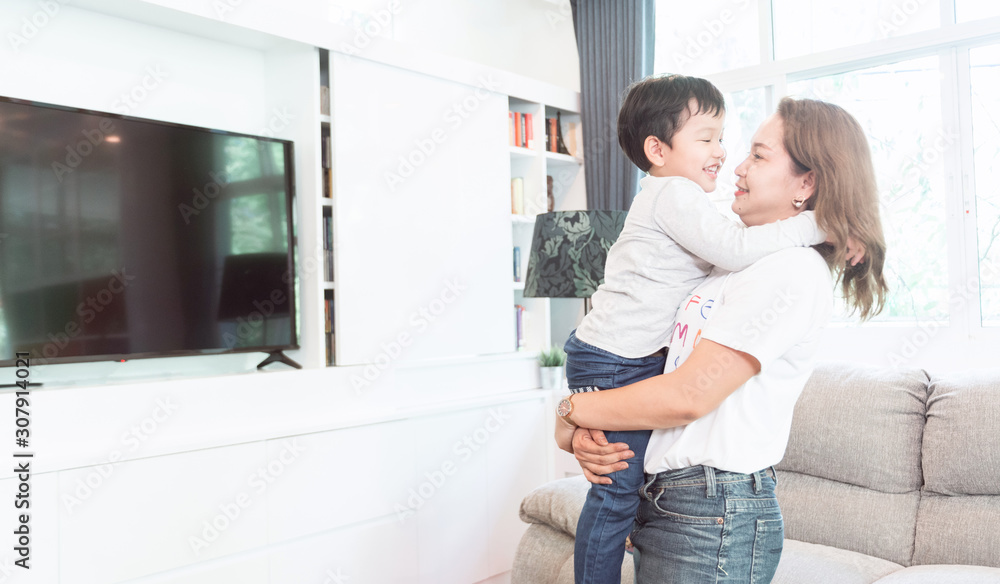 Loving young mother smiling and embracing her cute funny son to enjoying the moment together at home. Family concept Loving young mother smiling and embracing her cute funny son to enjoying the moment together at home. Family concept
