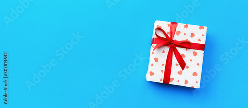 Gift box with red hearts on blue background. top view with copy space