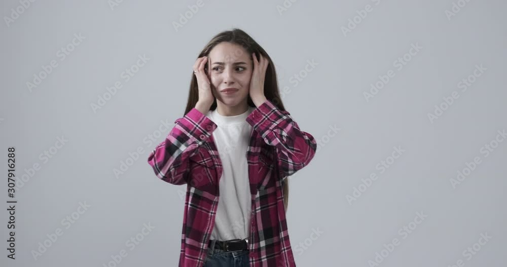 Depressed teenage girl expressing extreme shock over white background Depressed teenage girl expressing extreme shock over white background