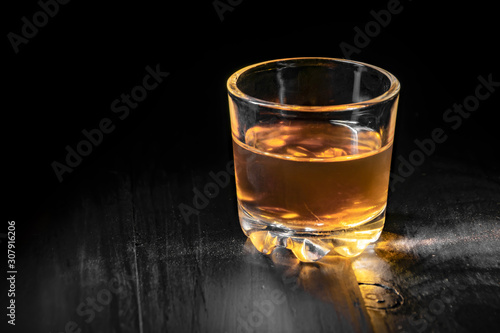 single glass of cognac on a black tree