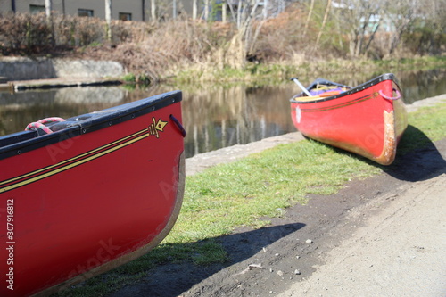 two red canoes on the edge of canal