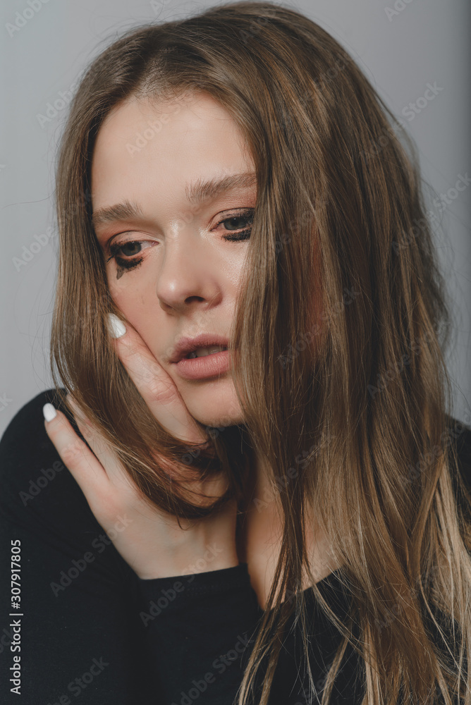 Portrait of a young beautiful long-haired girl who is upset crying. Portrait of a young beautiful long-haired girl who is upset crying.