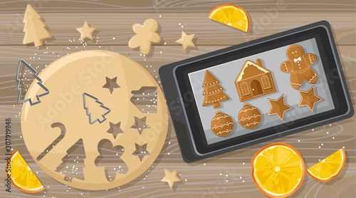 Christmas table with gingerbread cookies dough and metal forms. Orange slices...