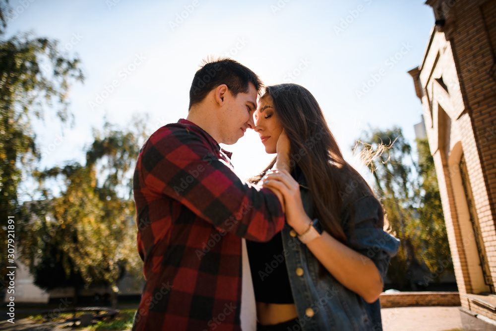 Man holding his woman on the face and looking into her eyes in the park