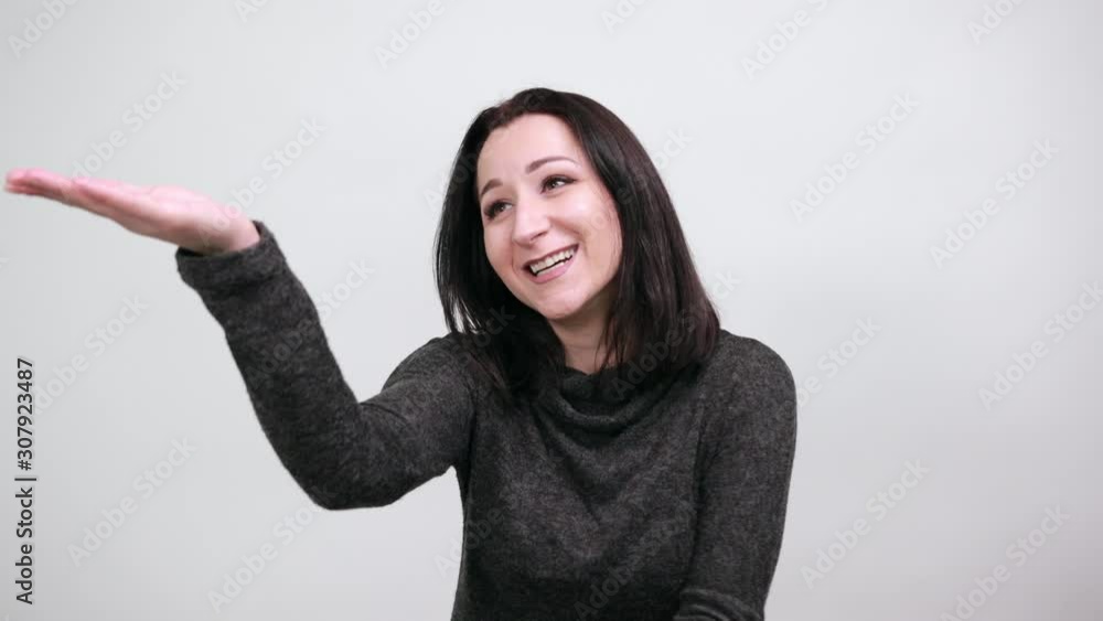 Beautiful caucasian young woman in black sweater pointing hands into distance, smiling over isolated white background, Lifestyle concept Beautiful caucasian young woman in black sweater pointing hands into distance, smiling over isolated white background, Lifestyle concept