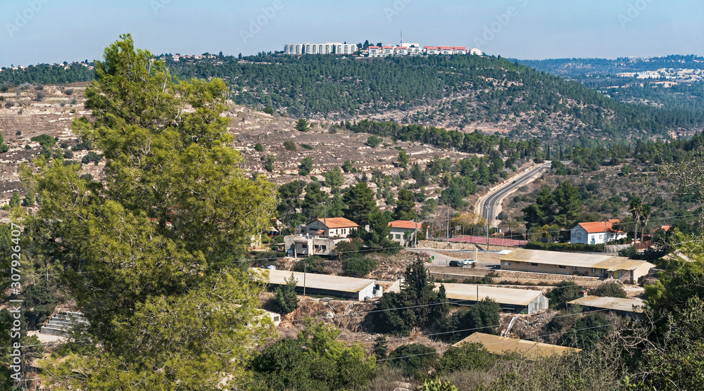 view of moshav shoresh in the judean mountains from the martyrs forest ya'ar kedoshim in central israel near jerusalem on a clear sunny day