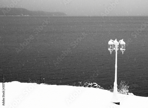 Winter River Landscape with Lightpost and Falling Snow