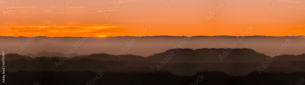 Amazing landscape  panorama background from a sunset with fog in the hills - black forest