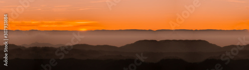 Amazing landscape panorama background from a sunset with fog in the hills - black forest