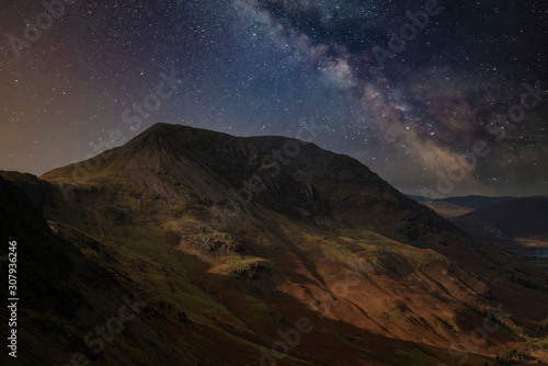 Stunning majestic digital composite landscape of Milky Way over Haystacks and High Stile in Lake District