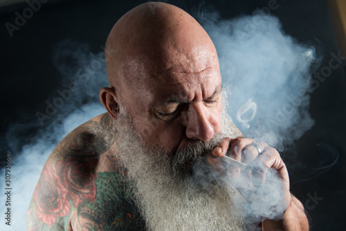 older man with beard smoking
