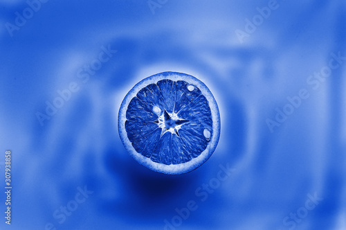 half an orange creatively tinted in classic blue.Classic blue color of the year 2020. Bright trendy texture. © kalfa