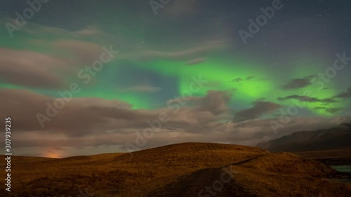 Aurora Borealis coloring the icelandic sky green over scenic landscape photo