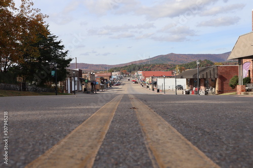 A street-level perspective view down a small town main street, Mena Street, Mena, Arkansas, with autumn colors on Rich Mountain in the background, small town America