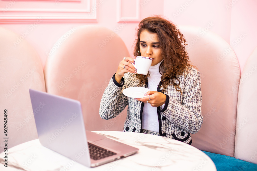 Young pretty woman with laptop and coffee standing in cafe Young pretty woman with laptop and coffee standing in cafe