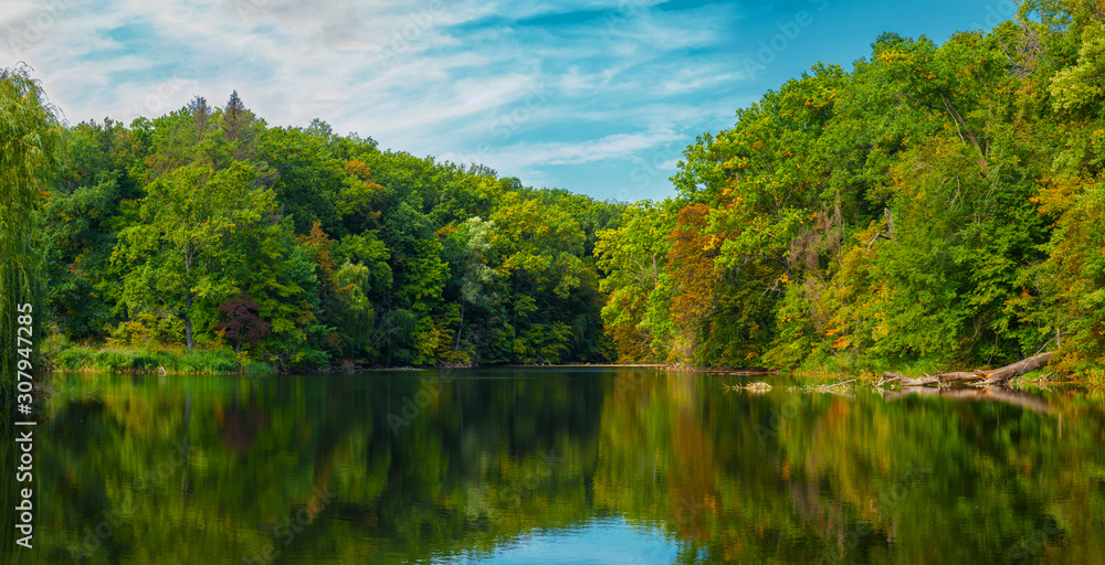 Trees with bright autumn foliage reflected in the water.