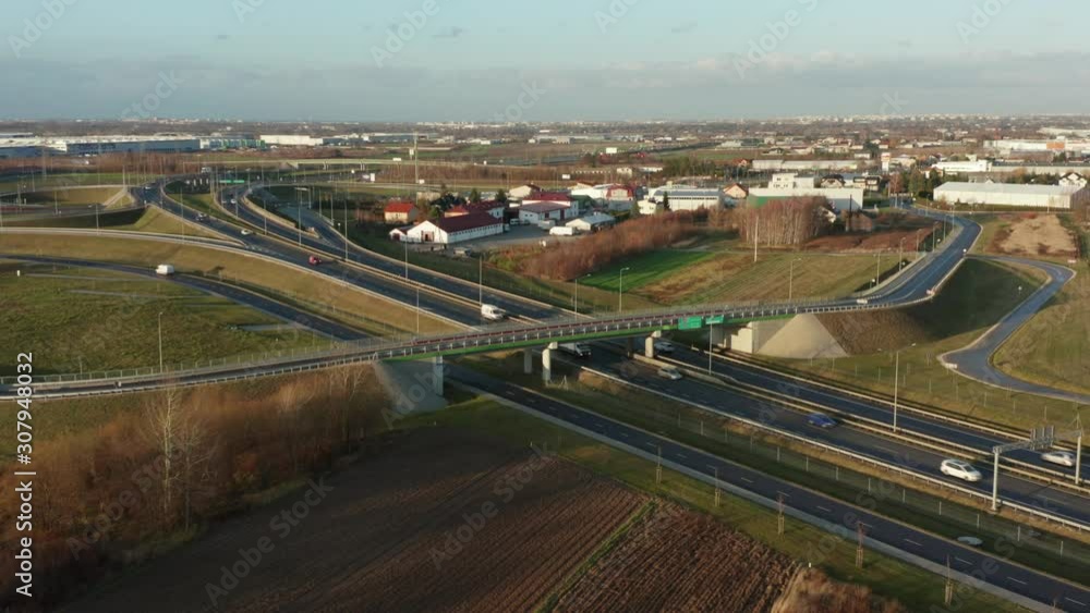 Drone shot shows the impressive elevation of the highway and the convergence of roads, bridges, viaducts in Poland at sunset, the development of transport and infrastructure. Drone shot shows the impressive elevation of the highway and the convergence of roads, bridges, viaducts in Poland at sunset, the development of transport and infrastructure.