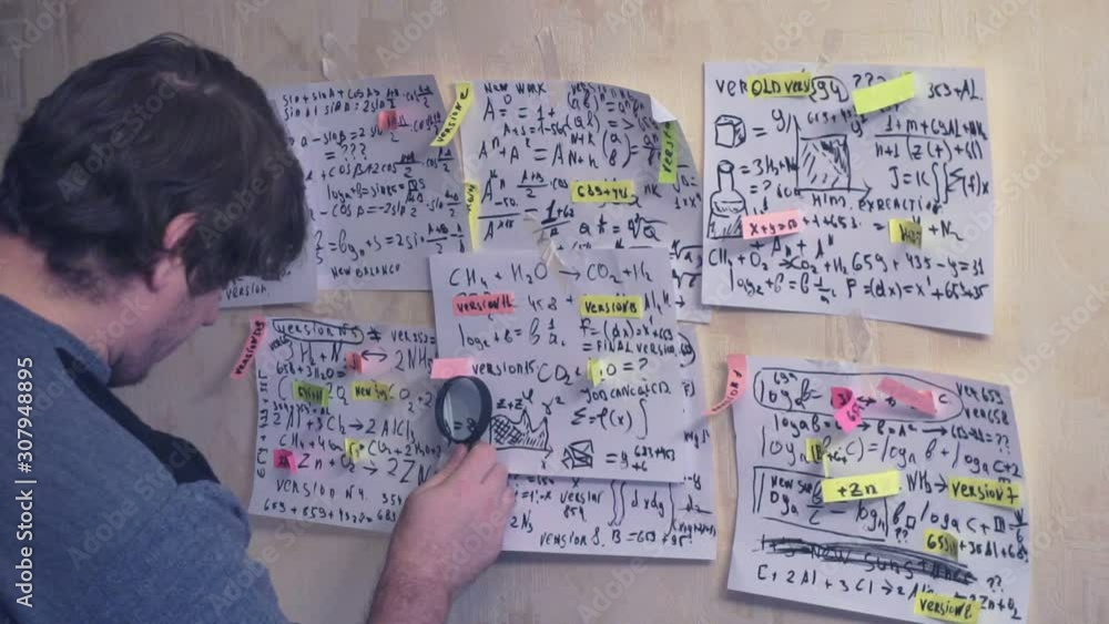 researcher works with various information on paper sheets that hang on the wall.research work. scientist in the workplace researcher works with various information on paper sheets that hang on the wall.research work. scientist in the workplace