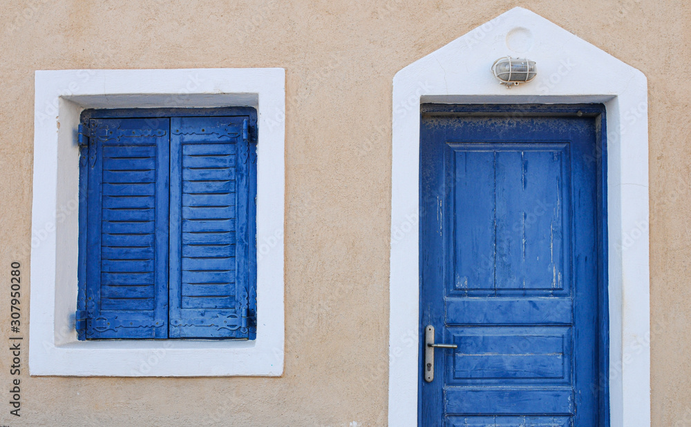 Traditional Greek island blue door and window with a white frame.