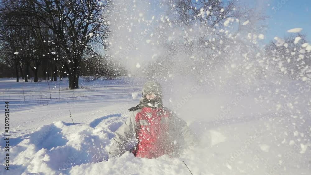 Happy kid throws up the snow at winter park Happy kid throws up the snow at winter park