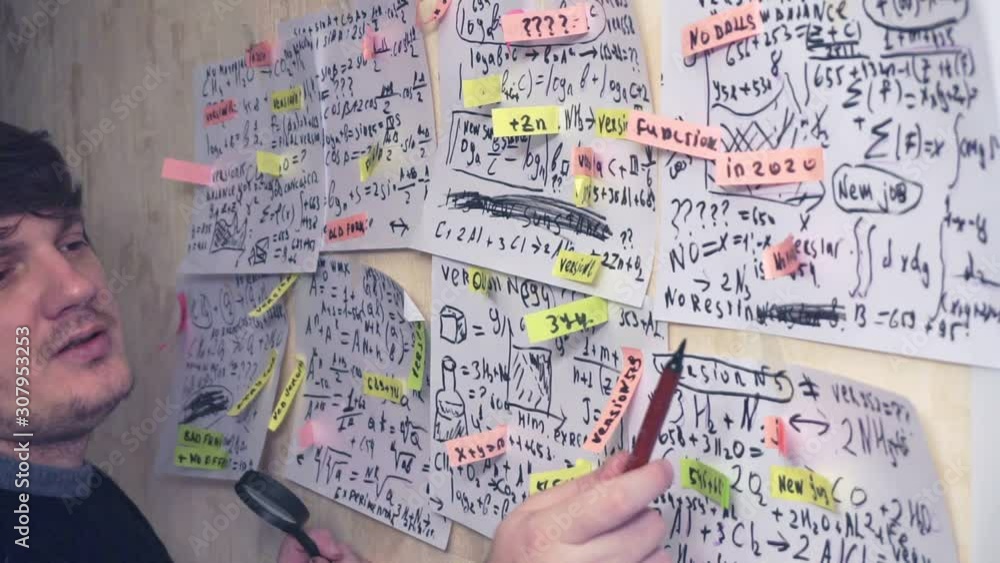 scientist works with various data on paper sheets that hang on the wall.research work.teacher in the workplace scientist works with various data on paper sheets that hang on the wall.research work.teacher in the workplace