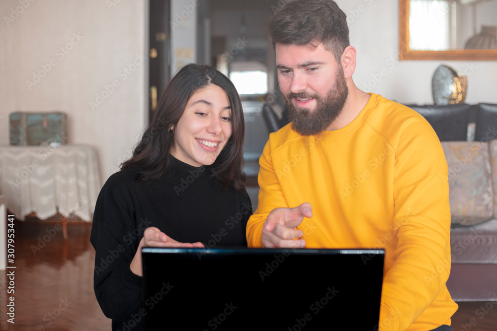 Young couple at home using computer and credit card Young couple at home using computer and credit card