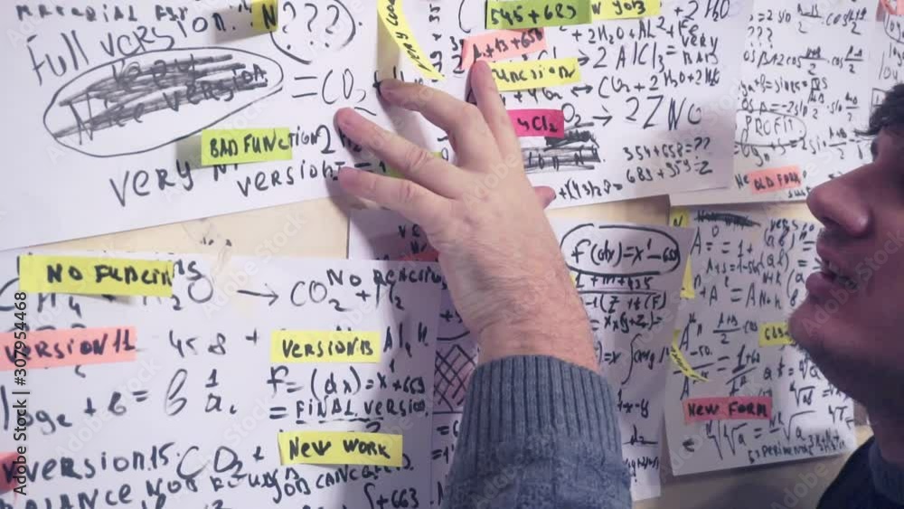 scientist works with various data on paper sheets that hang on the wall.research work.teacher in the workplace scientist works with various data on paper sheets that hang on the wall.research work.teacher in the workplace
