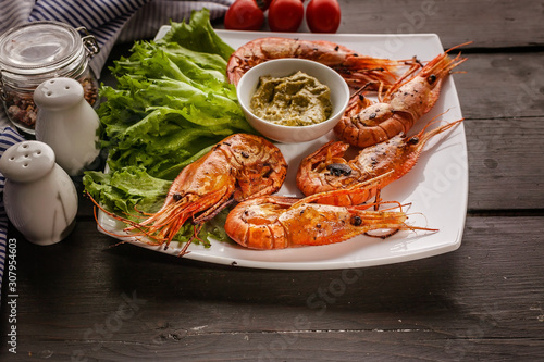 Close-up Grilled prawns with garlic and lemons on a white plate with lettuce