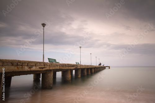 a long pier above the sea on a cloudy day