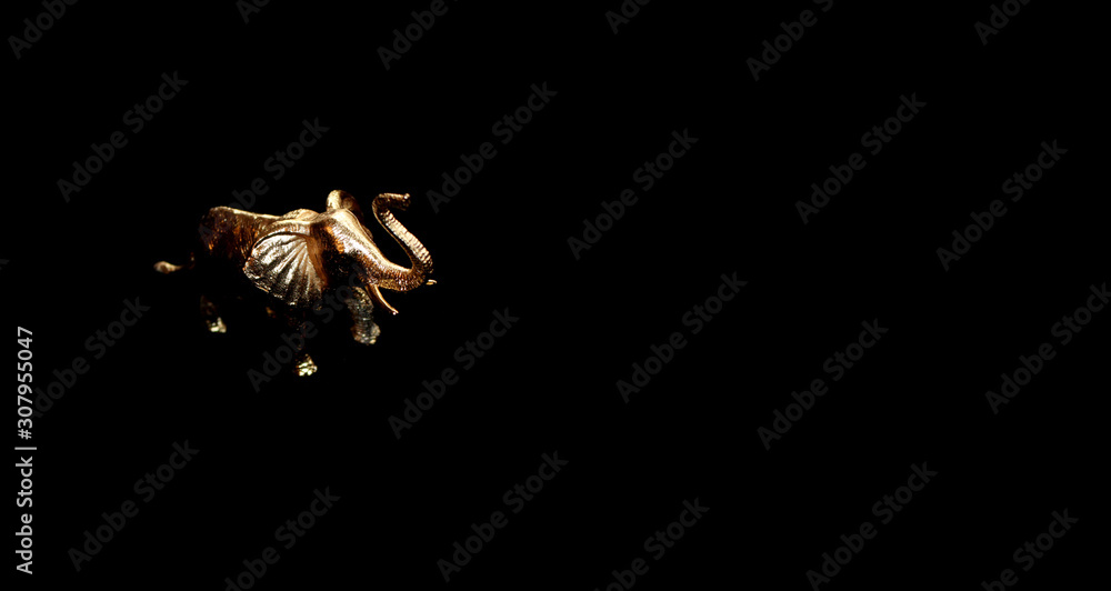 Naklejka premium Beautiful photo of the golden elephant metal sculpture in black background